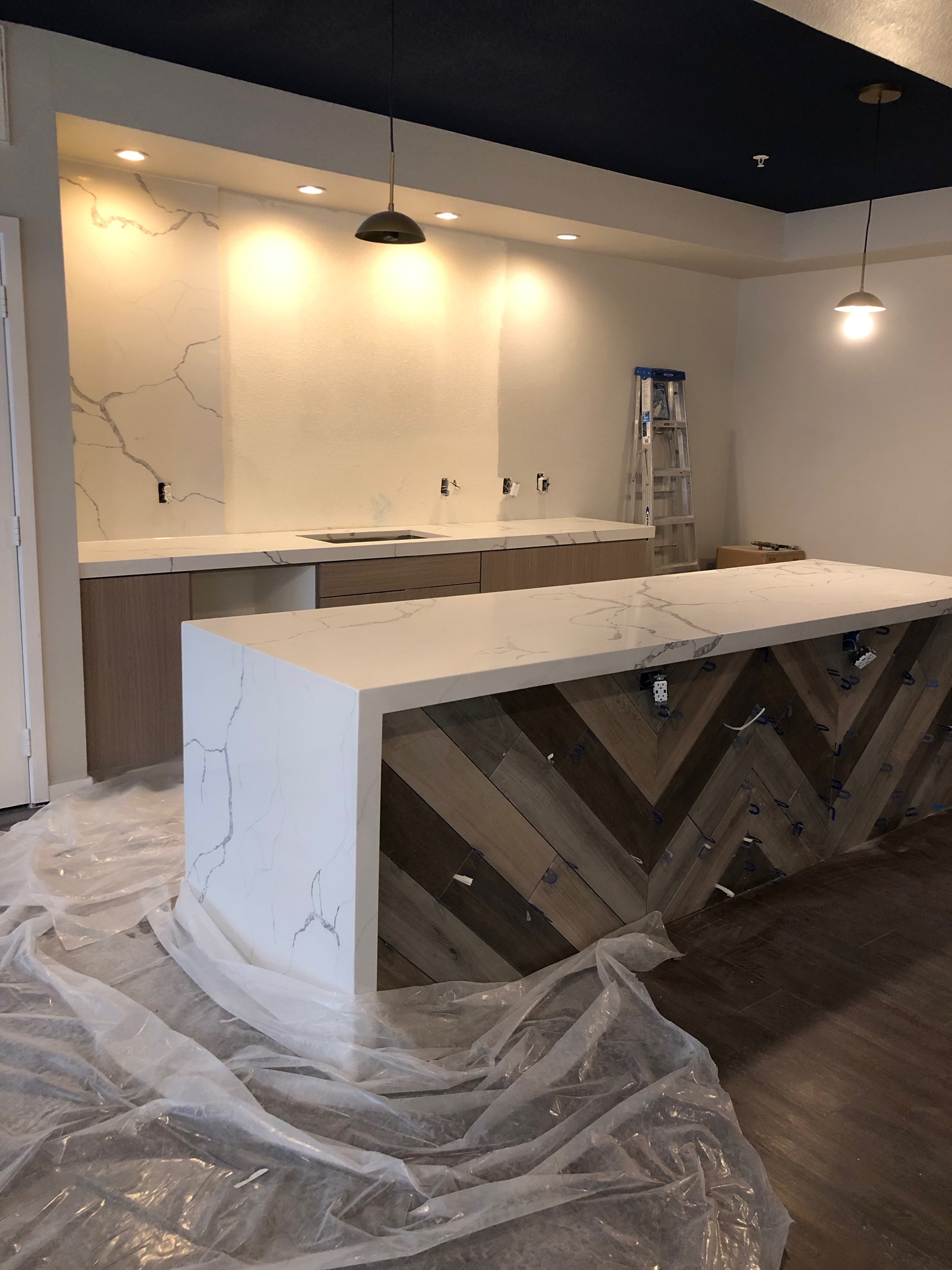 Detailed renovation with custom stone counter and herringbone paneling