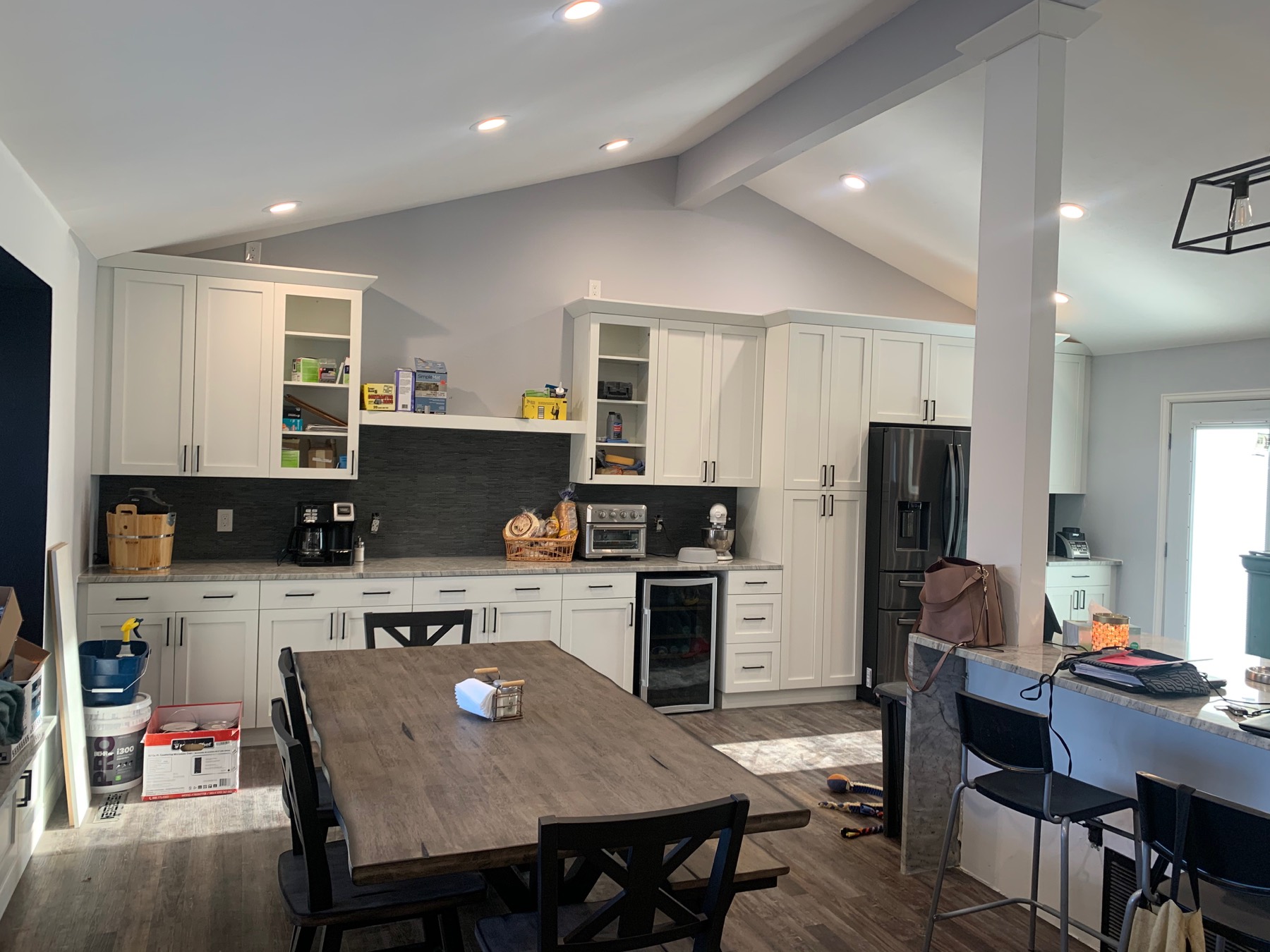 Open white kitchen with a long island and dark backsplash